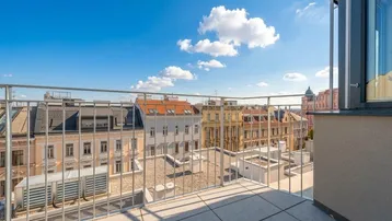 Geräumige Dachterrasse mit Fliesenboden und weitem Blick über die Stadt und historische Gebäude.