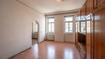Geräumiges Zimmer mit Einbauschränken aus Holz, Laminatboden und zwei Fenstern.