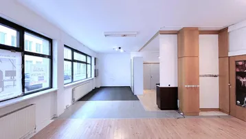 Geräumiger Innenraum mit Holzboden, großen Fenstern und verschiedenen Bodenbelägen, ideal für Büro oder Gewerbe.