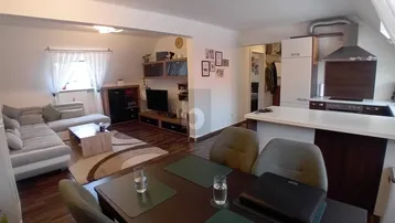 Offener Wohn- und Essbereich mit integrierter Küche, Holzboden und moderner Einrichtung.