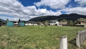 Weitläufiges Grundstück mit Blick auf die umliegende Berglandschaft und Nachbarhäuser.