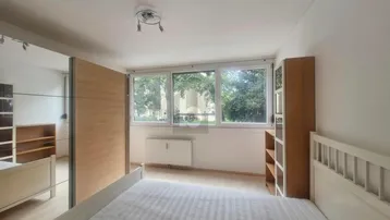 Helles Schlafzimmer mit Doppelbett, Spiegelschrank und Blick ins Grüne.