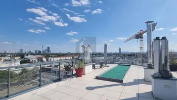 Geräumige Dachterrasse mit Panoramablick über die Stadt und einem Whirlpool im Freien.