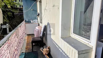 Schmaler Balkon mit Sitzgelegenheit und Blick ins Grüne, ideal für entspannte Stunden im Freien.