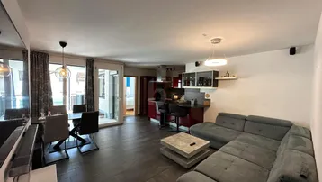 Helles, offenes Wohnzimmer mit integriertem Essbereich und moderner Küche, ideal für geselliges Beisammensein.