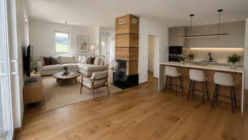 Helles, offenes Wohnzimmer mit integrierter Küche, Holzboden und modernem Kamin als Raumteiler.