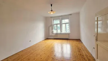 Helles Zimmer mit Holzboden und weiß gestrichenen Wänden, bereit zur individuellen Gestaltung.