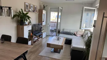 Heller offener Wohn- und Essbereich mit modernem Mobiliar und Zugang zum Balkon.