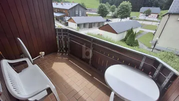 Gemütlicher Balkon mit Terrakotta-Fliesenboden und Blick auf die umliegende Landschaft.