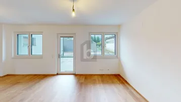Heller Wohnraum mit Holzboden, großen Fenstern und Zugang zur Terrasse, ideal für entspanntes Wohnen.