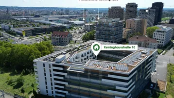 Luftaufnahme des Wohnkomplexes mit umliegenden Grünflächen und Bildungseinrichtungen.