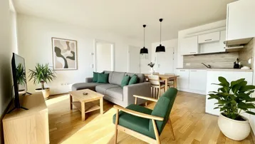Gemütlicher Wohn-Essbereich mit moderner Einrichtung, Parkettboden und offener Küche.