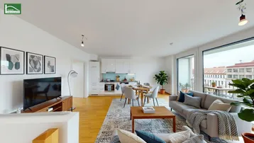 Helles, offenes Wohn-Esszimmer mit integrierter Küche, Parkettboden und Zugang zum Balkon.