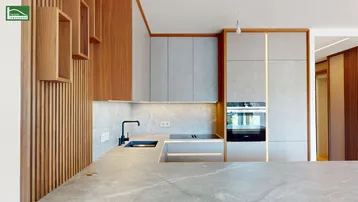 Moderne Küche mit grauen Fronten, Holzdetails und hochwertigen Einbaugeräten.