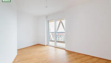 Helles, leeres Schlafzimmer mit Holzboden und Zugang zu einem französischen Balkon.