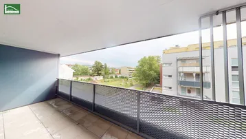 Geräumiger Balkon mit Fliesenboden und Metallgeländer, bietet Blick auf die Umgebung.