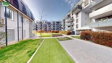 Moderner Innenhof mit Rasenflächen und Wegen zwischen den Wohngebäuden.