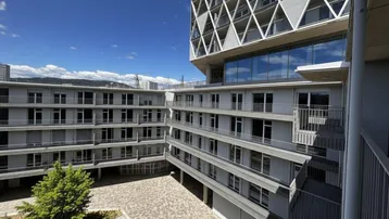 Innenhof des modernen Gebäudekomplexes mit Balkonen und markanter Fassadengestaltung.