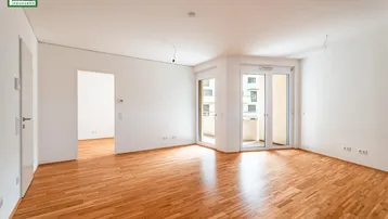 Helles Wohnzimmer mit Parkettboden und Zugang zu einem Balkon, bereit zur individuellen Gestaltung.