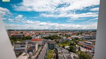 Panoramablick über eine Stadtlandschaft mit vielen Gebäuden und einem blauen Himmel.