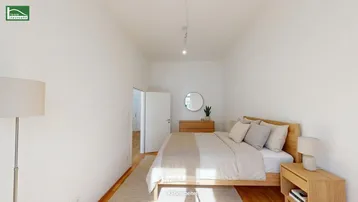 Helles Schlafzimmer mit Holzbett, Parkettboden und moderner Einrichtung, ideal zum Entspannen.