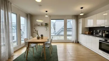Heller offener Wohn- und Essbereich mit moderner Küche, Parkettboden und Zugang zur Terrasse.