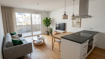 Helles, offenes Wohn-Esszimmer mit integrierter Küche, Parkettboden und Zugang zum Balkon.