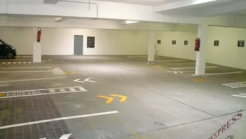 Saubere und gut beleuchtete Tiefgarage mit markierten Stellplätzen und Betonboden.