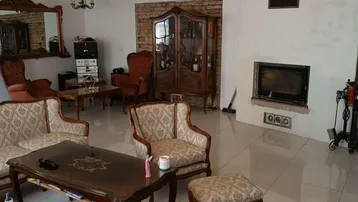 Gemütliches Wohnzimmer mit Kamin, antiken Sitzmöbeln und glänzenden Fliesen.