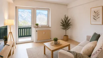 Helles Wohnzimmer mit Parkettboden, Balkonzugang und beeindruckendem Bergblick.