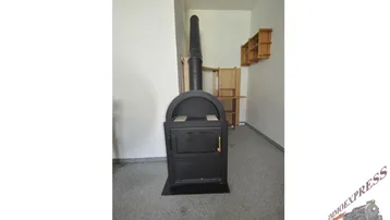 Moderner Holzofen in einem Raum mit Teppichboden, bereit für gemütliche Wärme.