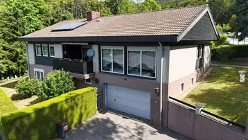 Ansicht des Hauses von vorne mit Garage, Balkon und gepflegtem Vorgarten.