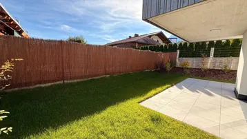 Gepflegter Garten mit Rasenfläche und blickdichtem Zaun, ideal für private Stunden im Freien.