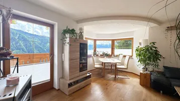 Helles Wohn- und Esszimmer mit Holzboden und beeindruckendem Bergblick durch große Fenster.