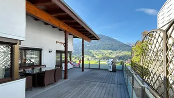 Große Terrasse mit Essbereich, Grill und Bergblick, ideal für entspannte Stunden im Freien.