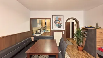Gemütlicher Essbereich mit Holzvertäfelung, Sitzbank und Blick in die Küche sowie den Flur.
