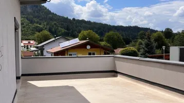 Geräumige Dachterrasse mit weitem Blick auf die umliegende Landschaft und Berge.