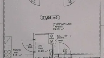 Grundriss des Erdgeschosses mit Wohnzimmer, Küche, separatem WC und Zugang zur Terrasse.