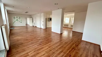 Großer, offener Büroraum mit Laminatboden und weißen Wänden, bereit für individuelle Gestaltung und Nutzung.