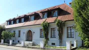 Traditionelles Gebäude mit mehreren Gaubenfenstern und einer charmanten Holztür.