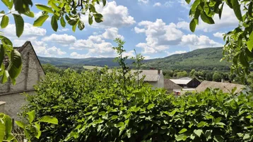 Malerischer Ausblick über die grüne Hügellandschaft und Dächer der Nachbarhäuser.