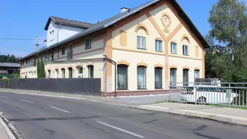 Historisches Gebäude mit traditioneller Architektur und gepflegter Fassade an einer Straße.