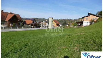 Weitläufige Grünfläche mit Blick auf die umliegende Wohnbebauung und sanfte Hügel.