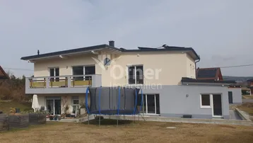 Rückseite des Hauses mit großem Garten, Rasenfläche und einem Trampolin.