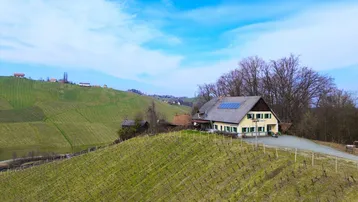 Luftaufnahme des Anwesens inmitten von Weinbergen mit Solaranlage auf dem Dach.