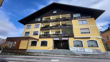 Gebäudeansicht des Finkenhofer mit traditioneller Architektur und mehreren Balkonen unter bewölktem Himmel.