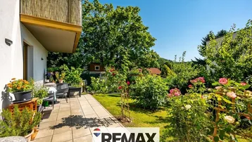 Geräumige Terrasse mit Gartenmöbeln und üppiger Bepflanzung, ideal für Entspannung im Freien.