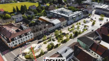 Luftaufnahme einer Stadtansicht mit Gebäuden, Straßen und einem belebten Platz.
