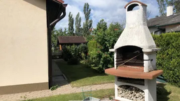 Gemauerter Grillplatz im Garten mit integriertem Stauraum für Brennholz.