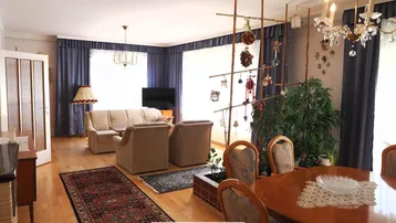 Geräumiger Wohn-Essbereich mit traditionellen Möbeln, Kronleuchter und Blick ins Grüne.